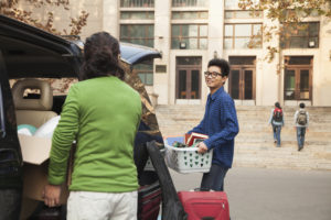 Young man moving into college dormitory