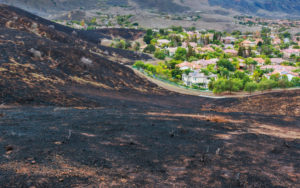 The burned hillside from a wildfire right up to the edge of homes