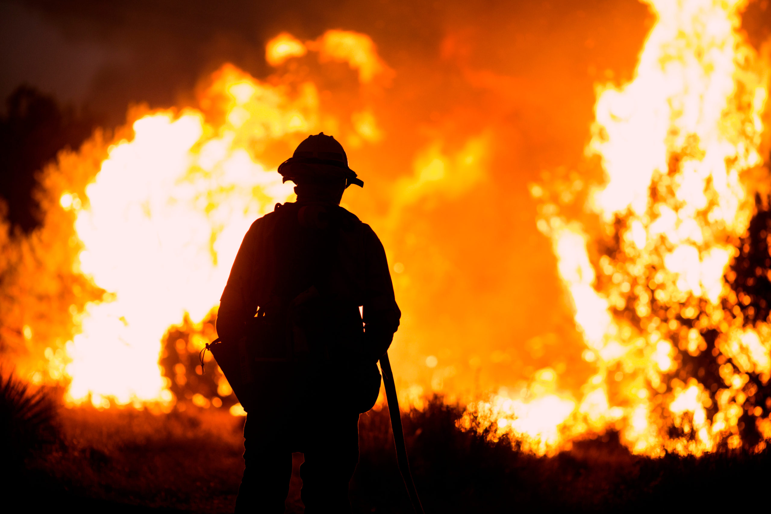 A firefighter watches the 2020 Bobcat Fire burn in Juniper Hills, Calif.