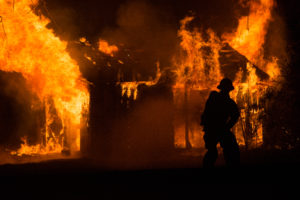 A firefighter works to put out a blaze in out building.