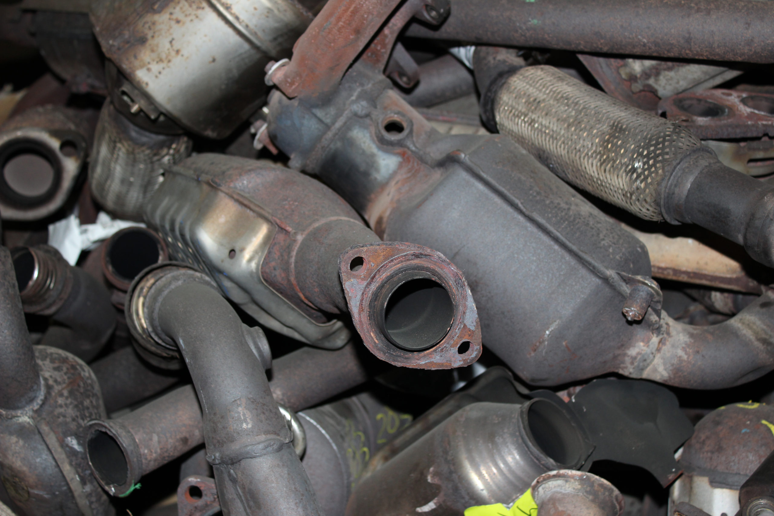 Old metal car parts, including catalytic converters.